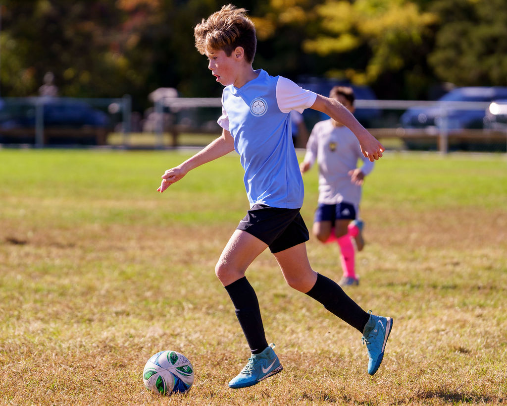 North Fork United player carrying the ball forward during a game