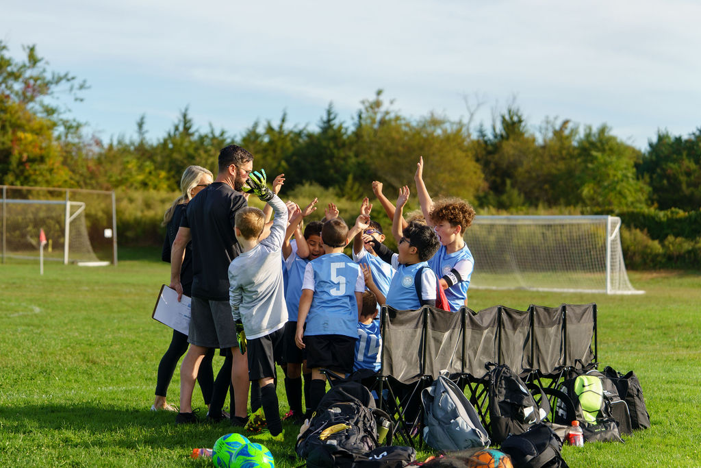 Coach speaking with a huddle of North Fork United youth players